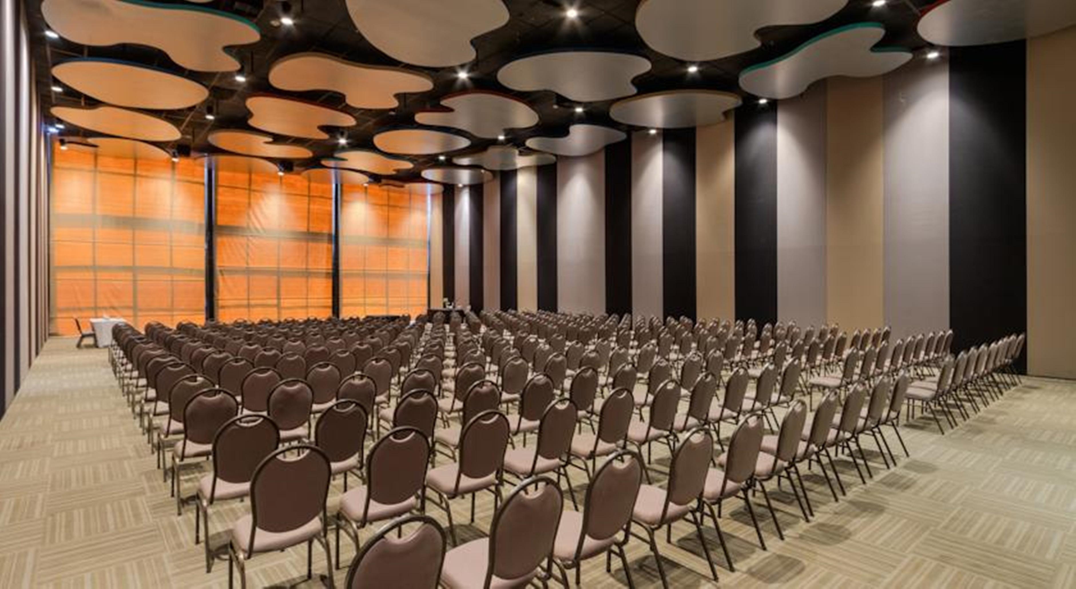 Hotel Royal Tulip Brasilia Alvorada Exterior foto The photo shows a large conference or event space filled with numerous empty chairs arranged in rows. The chairs have a simple design, with cushioned seats and backs. The walls of the room are decorated with a combination of dark and light tones, and